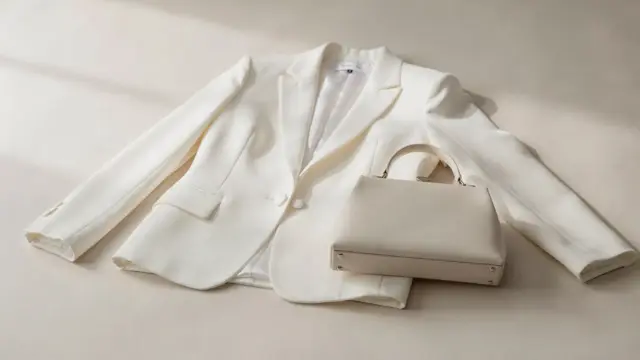 Brautjacke und Brauttasche als passende Accessoires zur Hochzeit auf hellem Hintergrund