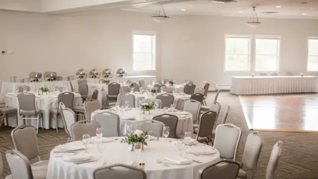 Hochzeitsraum mit Sitzordnung, Tanzfläche und Buffet in einer hellen Eventlocation