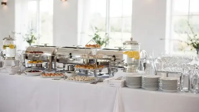 Hochzeitscatering mit Buffet, Getränkestation und gedeckten Tischen für eine Feier