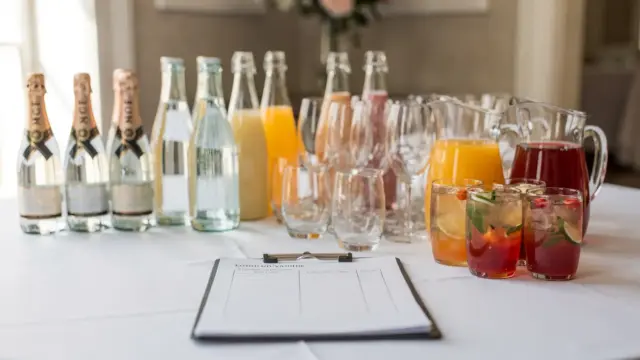 Getränkeauswahl und Kalkulation für eine Hochzeit mit Flaschen, Gläsern und Notizen