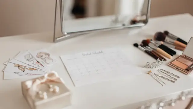 Bridal beauty appointment mit Kalender, Make-up-Tools und Frisur-Referenzen zum Hochzeit Frisur Make-up Termin