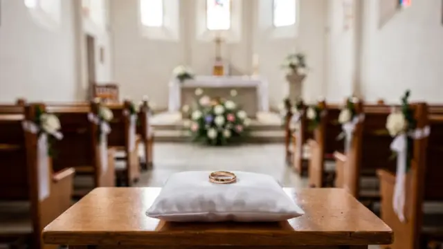 Leere evangelische Kirche mit Traugestaltung und Eheringen zum Thema kirchliche Trauung