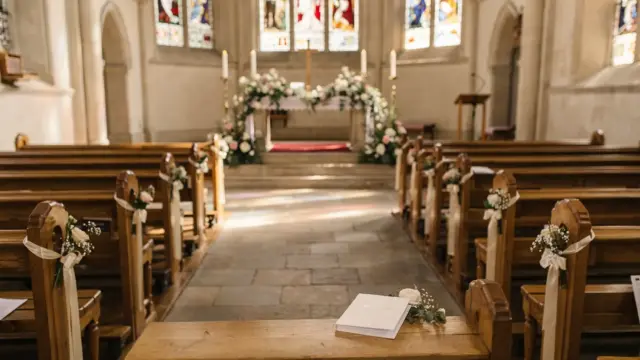 Kircheninnenraum zur kirchlichen Trauung mit Altar, Bänken und Brautstrauß